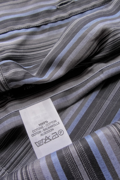 Waschanleitung Etikett auf Baumwollhemd mit vertikalen Streifen - Foto, Bild
