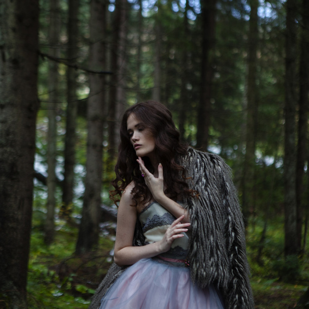 Portrait of romantic woman in beautiful dress in forest - Photo, Image