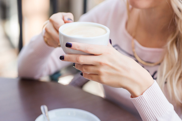 Hands of beautiful young girl holding coffe cup.  - Foto, imagen