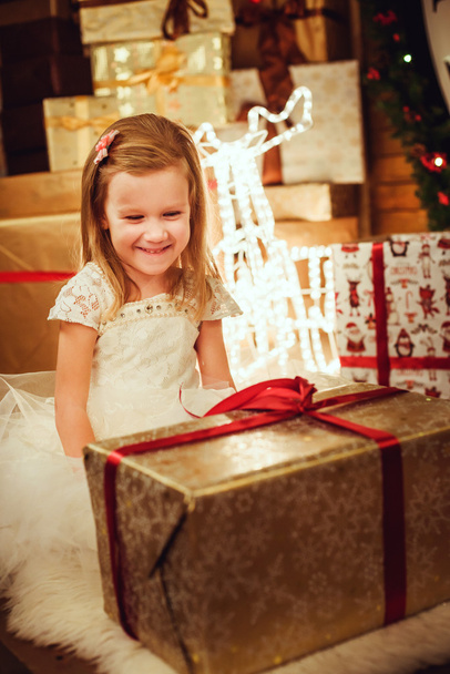 little pretty girl with presents sitting in  christmas decorations - Zdjęcie, obraz