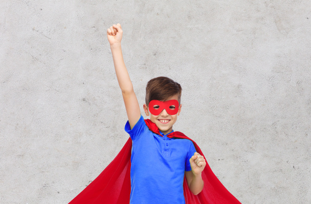 Junge in rotem Superheldenumhang und Maske mit Fäusten - Foto, Bild