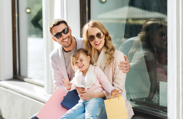 happy family with child and shopping bags in city - Foto, Imagem