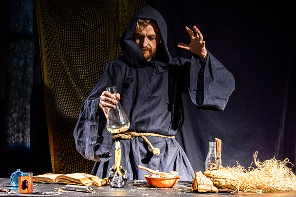 Portrait of a crazy medieval scientist working in his laboratory - Photo, Image