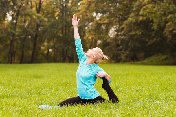 Woman practicing yoga in park - 写真・画像