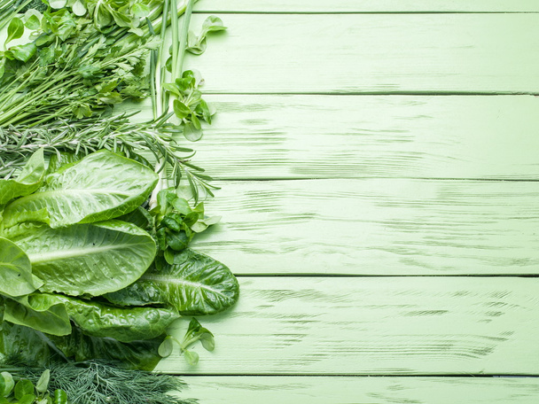 Green herbs on the green wooden background. - Photo, image