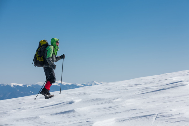 Hiker in winter mountains on sunny day - Φωτογραφία, εικόνα