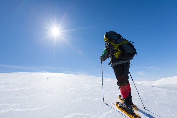 Caminhante snowshoeing em montanhas de inverno durante o dia ensolarado
 - Foto, Imagem