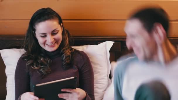 Happy Man and woman with the tablet on the bed. - Záběry, video