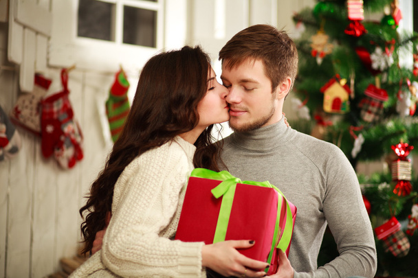 Happy couple with gift at home on a background of the Christmas  - Фото, изображение