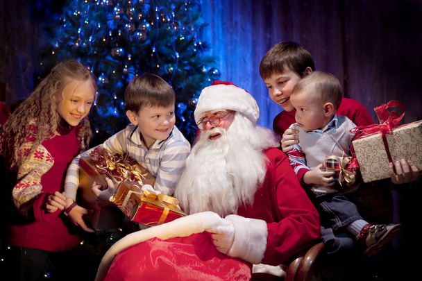 Santa giving Christmas Presents to Happy Children - Photo, Image