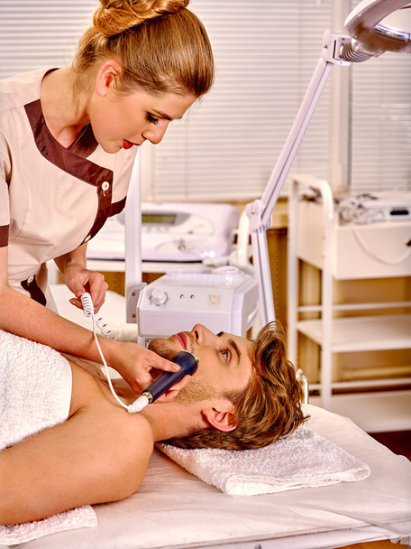 man receiving electric facial massage - Photo, Image