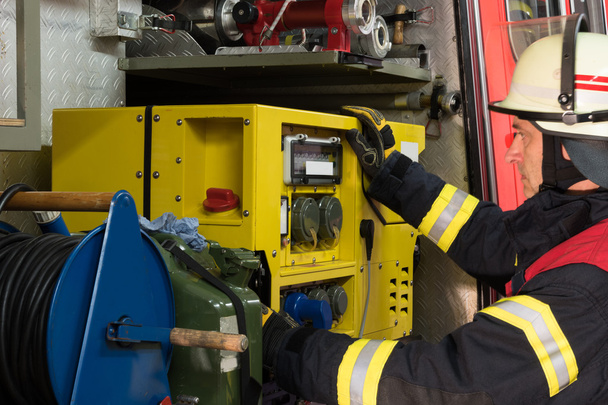 Strażak w akcji i używany generator energii elektrycznej - Zdjęcie, obraz