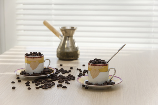 Dos tazas y granos de café sobre la mesa
. - Foto, imagen