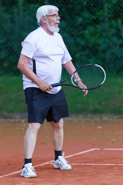 Senior man playing tennis - Фото, изображение