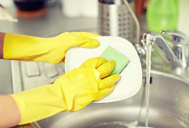 close up of woman hands washing dishes in kitchen - Фото, изображение