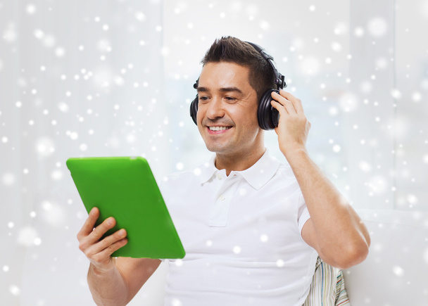 smiling man with tablet pc and headphones at home - Foto, Bild