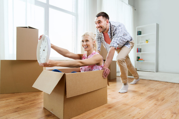 couple with cardboard boxes having fun at new home - Foto, imagen