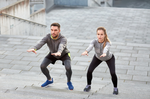 couple doing squats and exercising outdoors - Foto, Imagem