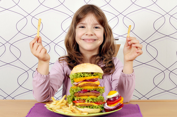 Маленькая девочка с большим гамбургером и картошкой фри
 - Фото, изображение
