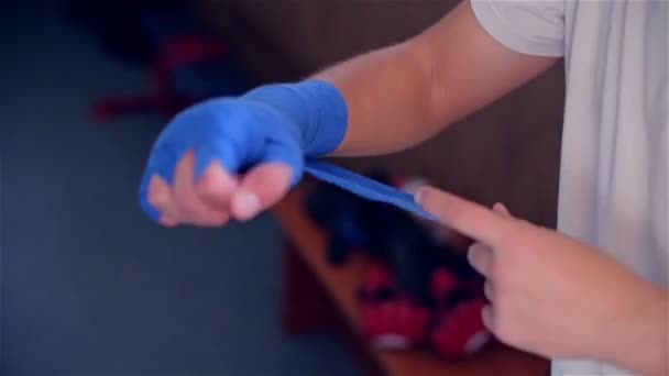 Mężczyzna wyciąga bandaż na rękę - Materiał filmowy, wideo