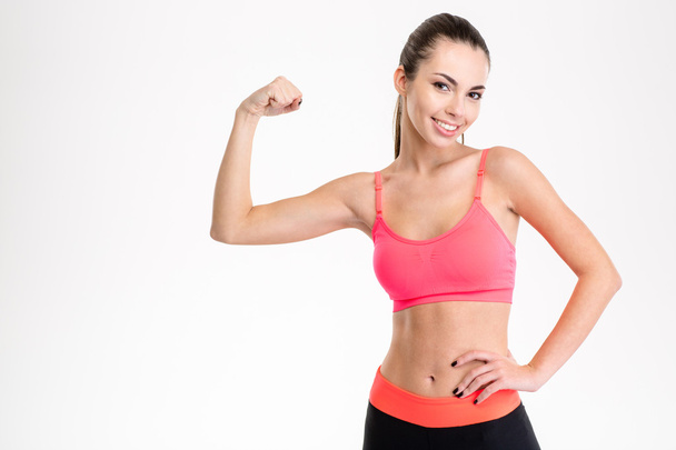 Smiling sports woman showing her bicep - Photo, Image