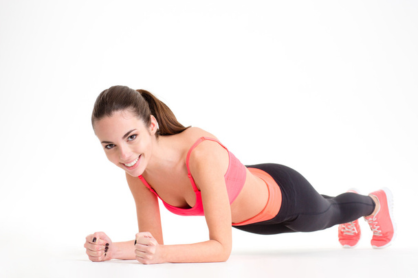 Cheerful beautiful fitness woman doing plank exercise  - Foto, imagen