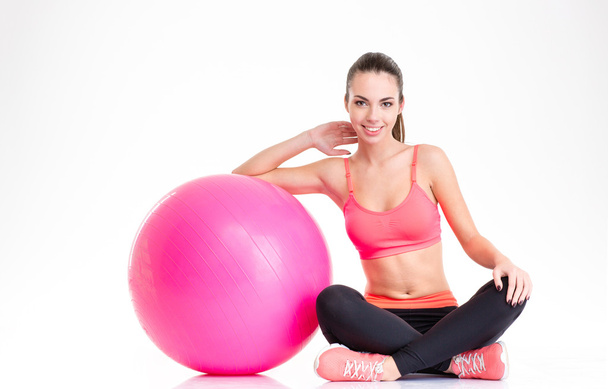 Hermosa chica de fitness feliz sentado y posando con fitball rosa
  - Foto, imagen