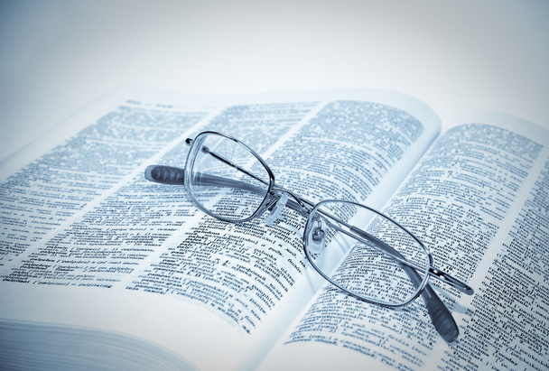 Closeup of opened book and glasses - Foto, imagen