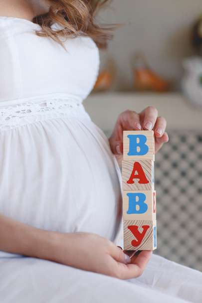 The pregnant woman with toy cubes in hands. - Foto, Bild