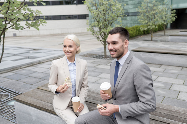 smiling businessmen with paper cups outdoors - Fotó, kép