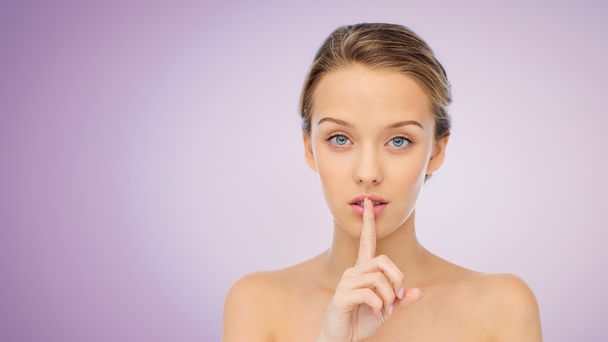 beautiful young woman holding finger on lips - Foto, immagini