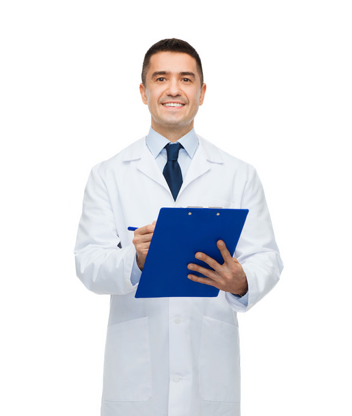 smiling male doctor with clipboard writing - Fotografie, Obrázek