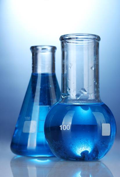 Tubos de ensayo con líquido azul sobre fondo azul
 - Foto, Imagen