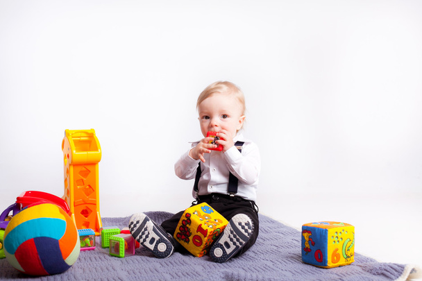 Little boy play with toys on blanket over white background - Zdjęcie, obraz