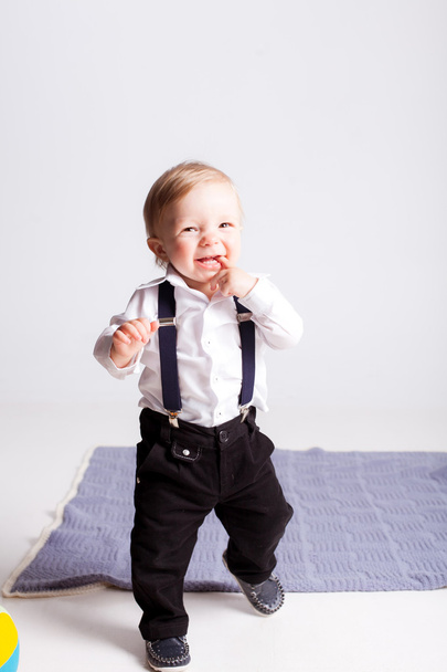 Boy holding his finger in mouth on white background - Fotó, kép