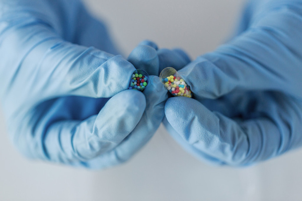 close up of scientist hands holding pill in lab - Zdjęcie, obraz