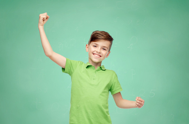 happy school boy in t-shirt showing strong fists - Фото, изображение
