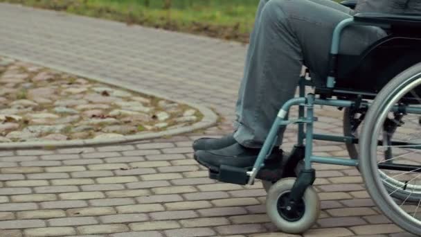 Hombre discapacitado usando silla de ruedas en el camino
 - Metraje, vídeo