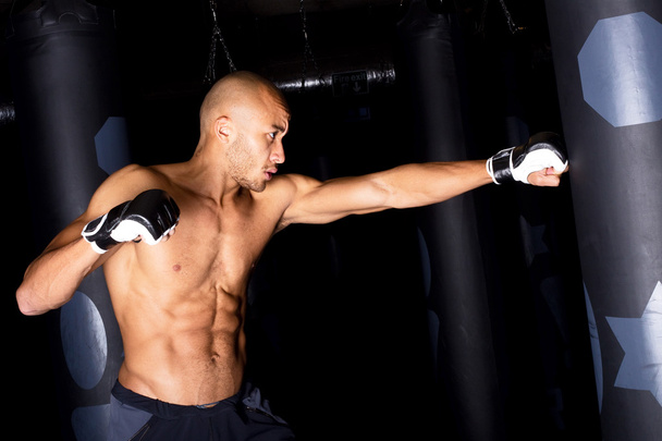 Man boxing a punch bag at the gym - Foto, Bild