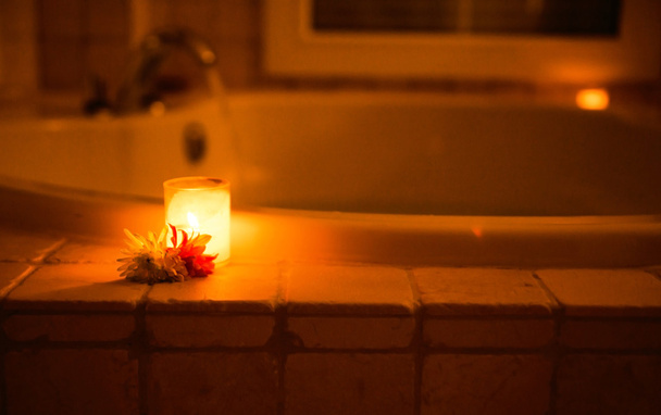 Candle in a glass candle holder near jacuzzi - Foto, imagen