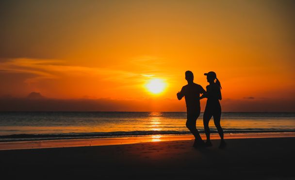 Junges Paar: Mann und Frau laufen bei Sonnenuntergang am Kakaosee zusammen - Foto, Bild