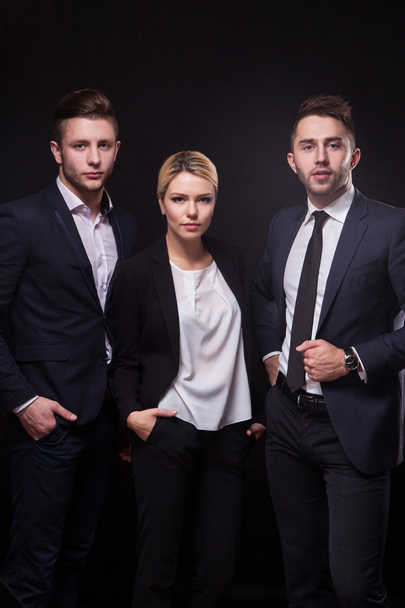 Team of three successful stylish young lawyers on a black backgr - Fotoğraf, Görsel