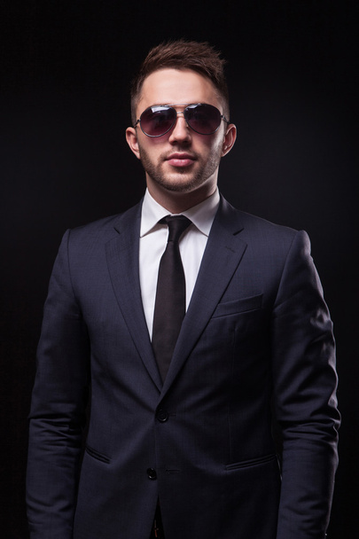 hombre de negocios elegante y de moda en un traje de negocios y gafas de sol en
 - Foto, imagen