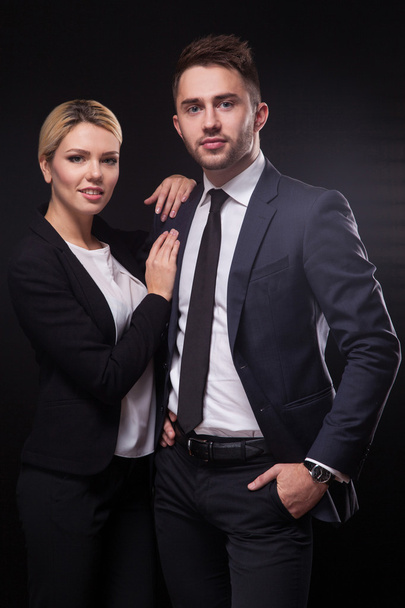 hombre y mujer de negocios elegantes, modernos y de moda en el respaldo negro
 - Foto, imagen