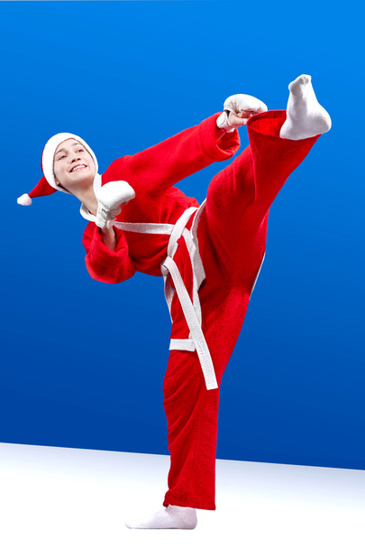 Спортсменка в костюме Санта-Клауса бьет по ноге
 - Фото, изображение