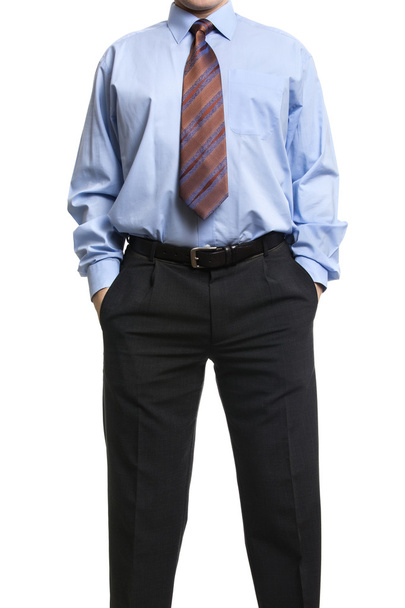 Empresario de camisa azul de pie con las manos en los bolsillos
 - Foto, Imagen