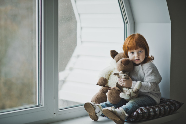 Girl with a toy sitting on the windowsill 4383. - Photo, Image