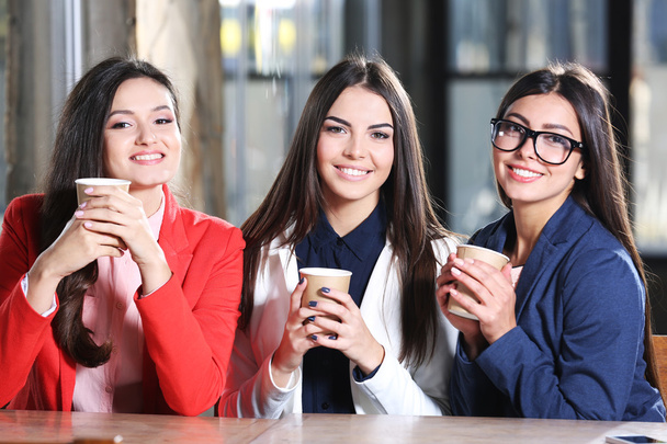 girls  hold cup of coffee sitting in cafe - Foto, immagini