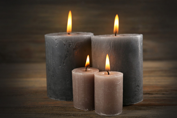 Alight wax grey candle on wooden background - Photo, Image