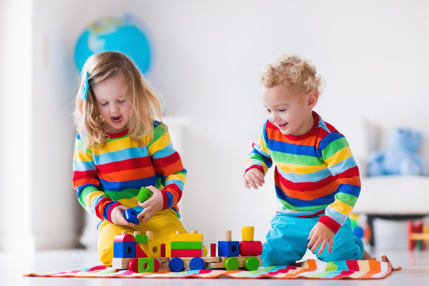 Crianças brincando com trem de brinquedo de madeira
 - Foto, Imagem